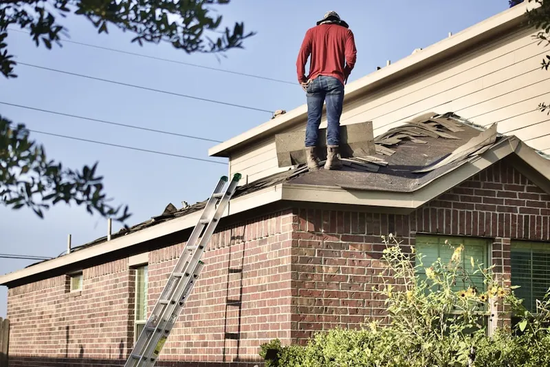 Professional roofer working on a residential roof in Beaver Hills